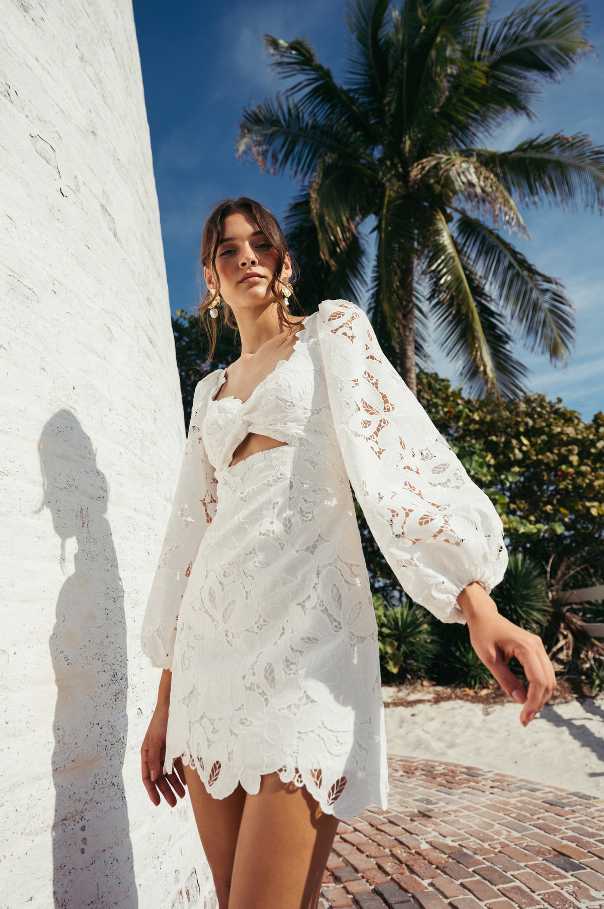 Jenny Yoo Chaya ivory bridal mini dress featuring structured bodice, sheer lace sleeves and fitted silhouette and romantic rception style design.
